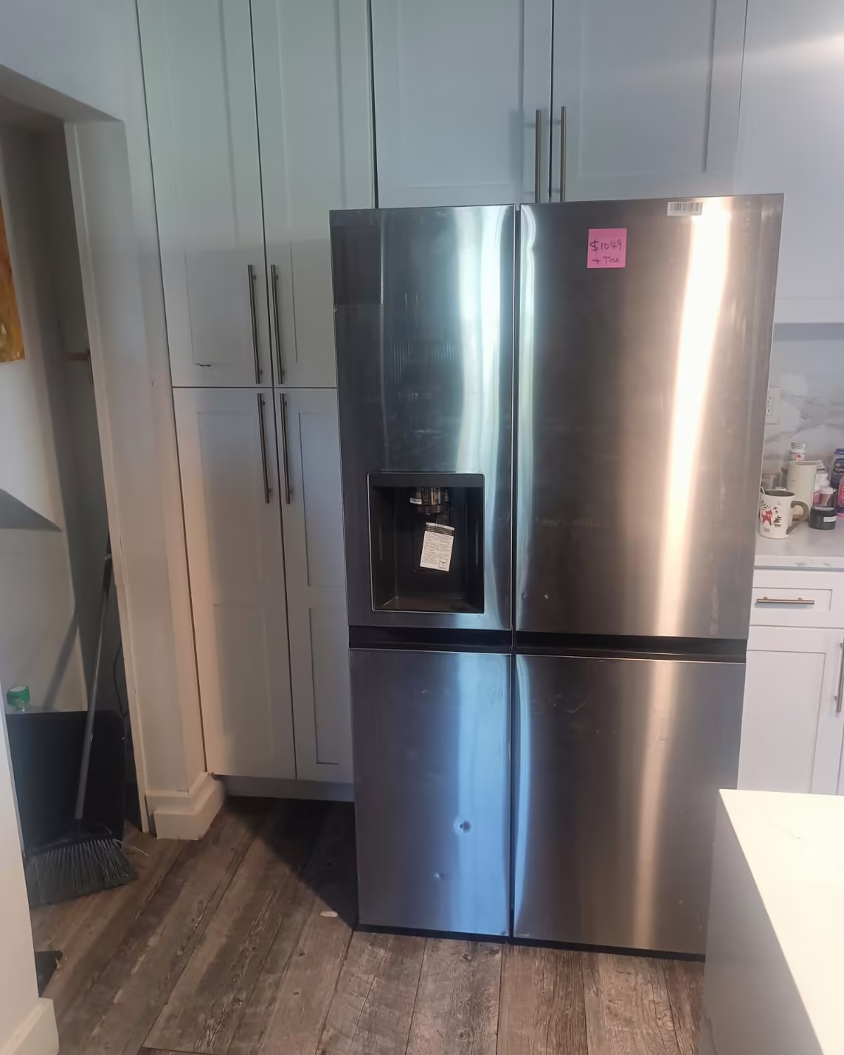 A stainless French-door refrigerator installed between kitchen cabinets