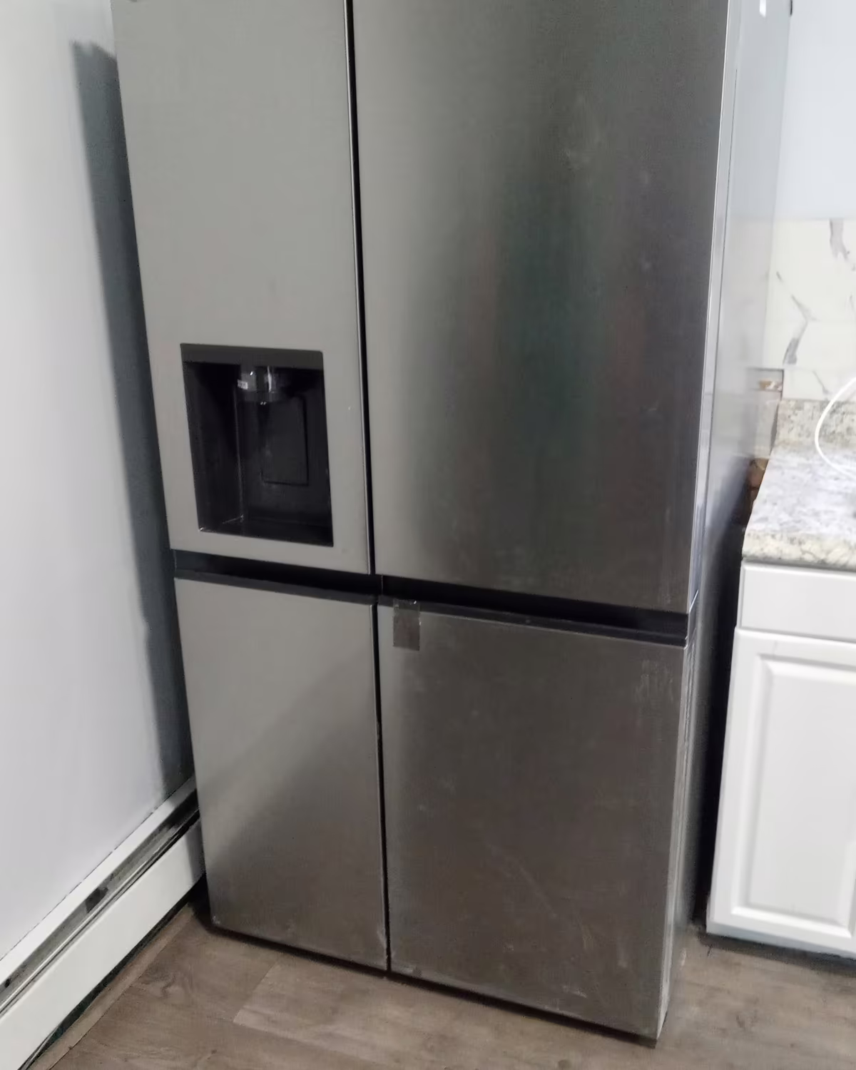 A stainless side-by-side refrigerator installed in a kitchen